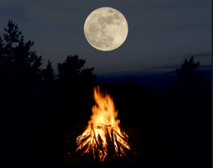 full moon behind campfire